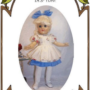 May include: A doll wearing a white dress with a blue trim and a blue bow in her hair. The doll is holding a teacup and saucer. The image is from a pattern for a doll's dress. The text on the image reads "Style 200 14.5 Toni design by Olson Marsha Daddy's Little Princess Perfect Patterns for Footson Dolls 1998-2010"