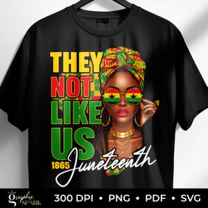 May include: Black t-shirt with a graphic design featuring a woman wearing a colorful head wrap and sunglasses with a star and flag design. The text reads "THEY NOT LIKE US 1865 Juneteenth."