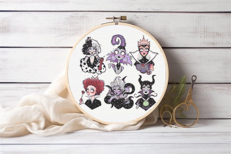 May include: A white embroidery hoop with a white fabric inside. The fabric has six embroidered images of Disney villains, including Cruella de Vil, Maleficent, and Ursula. The villains are all depicted in a cartoon style with black outlines.