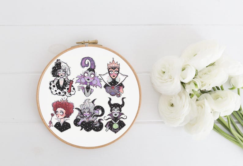 May include: Embroidered hoop art featuring Disney villains. The villains include Cruella de Vil, Maleficent, Ursula, the Evil Queen, and Queen of Hearts. The hoop is white with a black background and the villains are all in black and white.