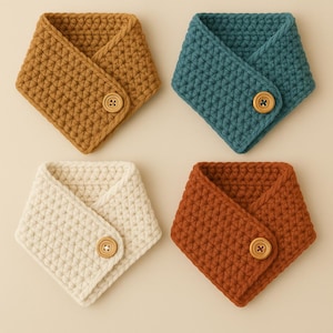 Peut inclure: Quatre cols tricotés en jaune moutarde, bleu sarcelle, crème et rouille. Chaque écharpe est fermée par un bouton. Les articles sont présentés sur un fond neutre.