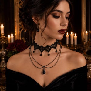 May include: A black lace choker necklace featuring heart-shaped motifs and dangling black teardrop beads. The piece includes two delicate metal chains layered below the lace, with a central teardrop pendant. Matching black teardrop earrings.