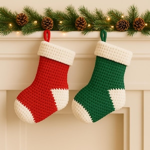 Può includere: Due calze di Natale fatte a mano, una rossa e una verde, con dettagli e polsini bianchi. Le calze sono all'uncinetto e hanno un anello per appenderle. Decorazioni festive.
