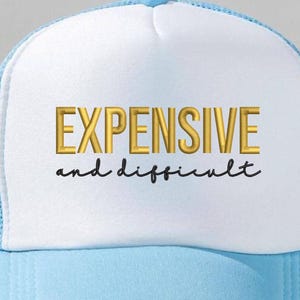 Könnte beinhalten: Hellblau-weiße Trucker-Cap mit dem Schriftzug "EXPENSIVE and difficult" in Gold und Schwarz. Die Cap hat einen Mesh-Rücken und einen gebogenen Schirm. Ein modisches Accessoire.
