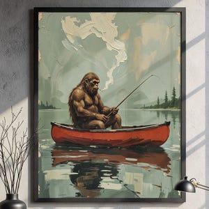 May include: A framed illustration of a large, brown, hairy figure sitting in a red canoe and fishing. The figure is wearing a red bandana and has a cigarette in its mouth. The canoe is floating on a blue lake with green trees in the background. The sky is blue with white clouds.