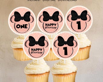 May include: Six pink and white cupcake toppers with black bows and the text "Happy Birthday" and "One" on them.