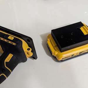 May include: A black and yellow power tool and battery pack. The power tool has a black handle and a yellow body. The battery pack is yellow and black, with the text "DEWALT" on the side.