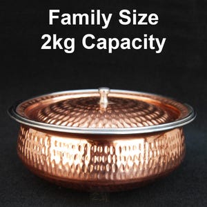 Puede incluir: Un cuenco de metal martillado de color cobre con tapa. El cuenco tiene un borde plateado y un pequeño asa en la tapa. El texto de la imagen dice "Family Size 2kg Capacity".