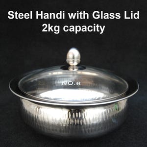 May include: A silver steel handi with a glass lid. The handi has a hammered finish and a capacity of 2 kg. The lid has a knob on top and the number "NO. 6" is printed on the lid.