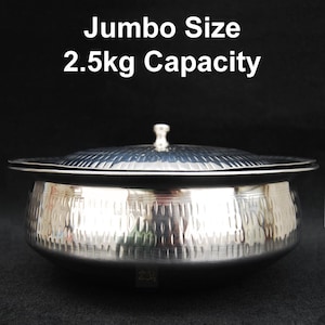 Puede incluir: Un bol de servir plateado con tapa. El bol tiene un acabado martillado y una capacidad de 2,5 kg. El texto "Jumbo Size 2.5kg Capacity" está impreso sobre un fondo negro encima del bol.