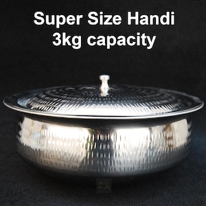Puede incluir: Un handi de acero inoxidable plateado martillado con tapa. El handi tiene una capacidad de 3 kg y está etiquetado como "Super Size Handi".