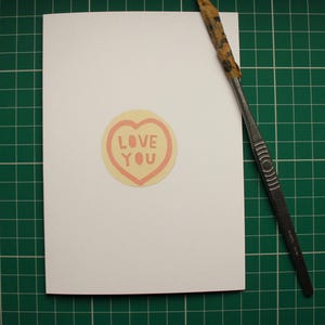 Ti amo. Dolce biglietto di San Valentino a forma di cuore, carta tagliata a mano e stampata professionalmente su cartoncino riciclato. Il 15% dei profitti andrà all'Hospice St Elizabeth.