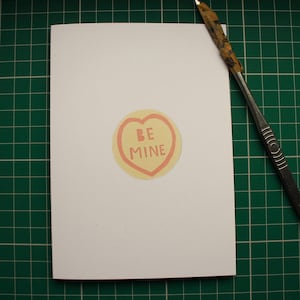 Be Mine. Dolce biglietto di San Valentino a forma di cuore, carta tagliata a mano e stampata professionalmente su cartoncino riciclato. Il 15% dei profitti andrà all'Hospice St Elizabeth.