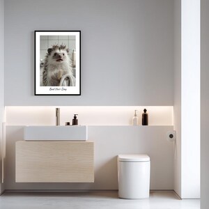 May include: A framed print of a hedgehog with wet fur, looking at the camera. The print is in a black frame and has the text "Bad Hair Day" below the image.