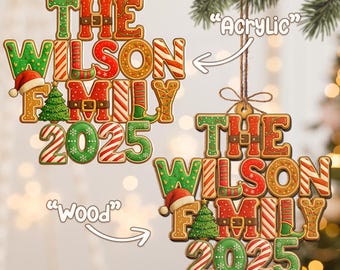 May include: Two Christmas ornaments with the text "THE WILSON FAMILY 2025". One is made of wood and the other of acrylic. The ornaments have a gingerbread cookie design with red, green, and white accents, including a Santa hat and Christmas tree.