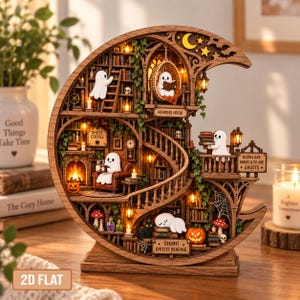 May include: A crescent moon-shaped wooden diorama featuring multiple levels of a library with miniature white ghosts, bookshelves, a fireplace, and a spiral staircase. Text includes "READING NOOK", "GHOST COFFEE", "BOOKS ARE MAGIC & SO ARE GHOSTS", and "SHHH! GHOSTS READING".