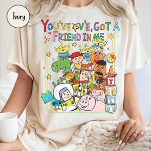 May include: A white ceramic mug with a black handle and the text "But First, Coffee" in a bold, black font. The mug is set against a neutral background, highlighting its simple design.