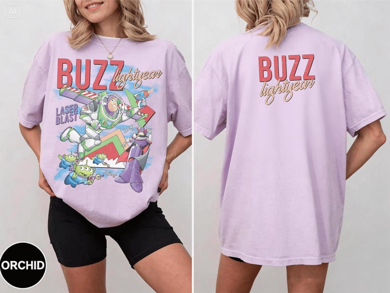 May include: A light purple t-shirt featuring a graphic of Buzz Lightyear and the text "BUZZ lightyear" in red and gold. The back of the shirt also has the text "BUZZ lightyear" in red and gold.