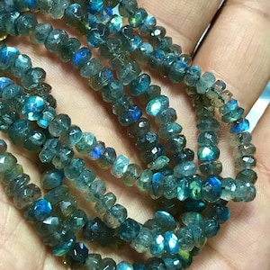 Op de afbeelding: Een streng facetgeslepen labradorit kralen in tinten blauw en groen. De kralen zijn ongeveer 4 mm groot en hebben een hoogglans afwerking.