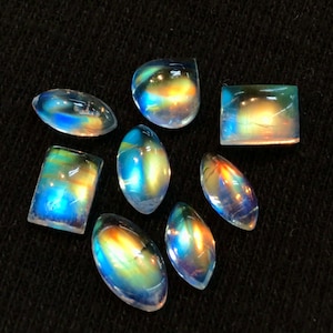 Puede incluir: Surtido de cabujones de piedras preciosas iridiscentes en varias formas y tama&ntilde;os. Las piedras tienen un arco&iacute;ris de colores, incluyendo azul, verde, amarillo y naranja.