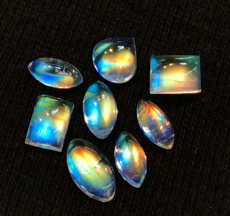 Puede incluir: Surtido de cabujones de piedras preciosas iridiscentes en varias formas y tama&ntilde;os. Las piedras tienen un arco&iacute;ris de colores, incluyendo azul, verde, amarillo y naranja.