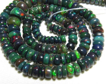 May include: A strand of dark green, black, and iridescent opal beads. The beads are round and have a smooth, polished finish.