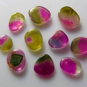 May include: Assortment of ten natural gemstones, each with a unique combination of green, pink, and yellow hues. The stones are smooth and polished, with a variety of shapes and sizes.