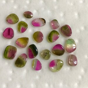 May include: A collection of 18 smooth, polished, multi-colored gemstones. The stones are a mix of green, pink, and black, with some showing a layered effect.