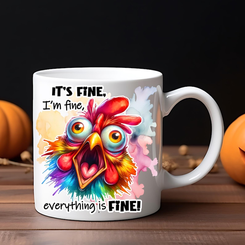 Pode incluir: Uma caneca de cer&acirc;mica branca com uma ilustra&ccedil;&atilde;o de uma galinha de olhos arregalados e plumagem vibrante e multicolorida. O texto "IT'S FINE, I'm fine, everything is FINE!" est&aacute; impresso em letras pretas acima e abaixo do gr&aacute;fico.