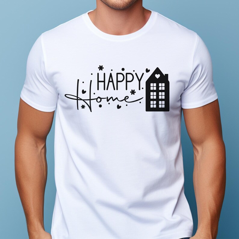 May include: A white short-sleeved t-shirt featuring a black graphic print on the chest. The design includes the text "HAPPY HOME" in a stylized font, accompanied by small heart and flower icons and a silhouette of a house with a heart window.