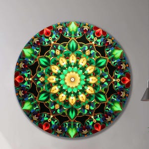 May include: A round wall art piece featuring a vibrant mandala design. The artwork showcases a symmetrical pattern with green, yellow, red, and blue floral elements set against a black background, framed by gold accents. The piece is mounted on a white wall.