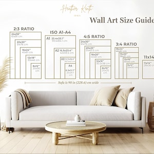 May include: A wall art size guide with dimensions in inches and centimeters. The guide includes ratios such as 2:3, ISO A1-A4, 4:5, 3:4, and 11x14. The image also shows a white sofa, a round wooden coffee table, and decorative items.