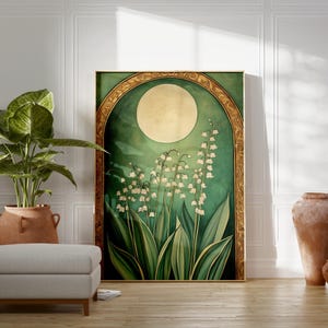 May include: A framed art print featuring a stylized depiction of lily of the valley flowers under a full moon. The artwork has a green and gold color scheme, with a large, round moon and detailed floral elements. The print is displayed in a room with a plant and decorative vases.
