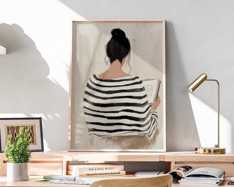 May include: A black and white striped shirt with a woman reading a book. The woman has dark hair pulled back in a bun. The background is a light beige color.