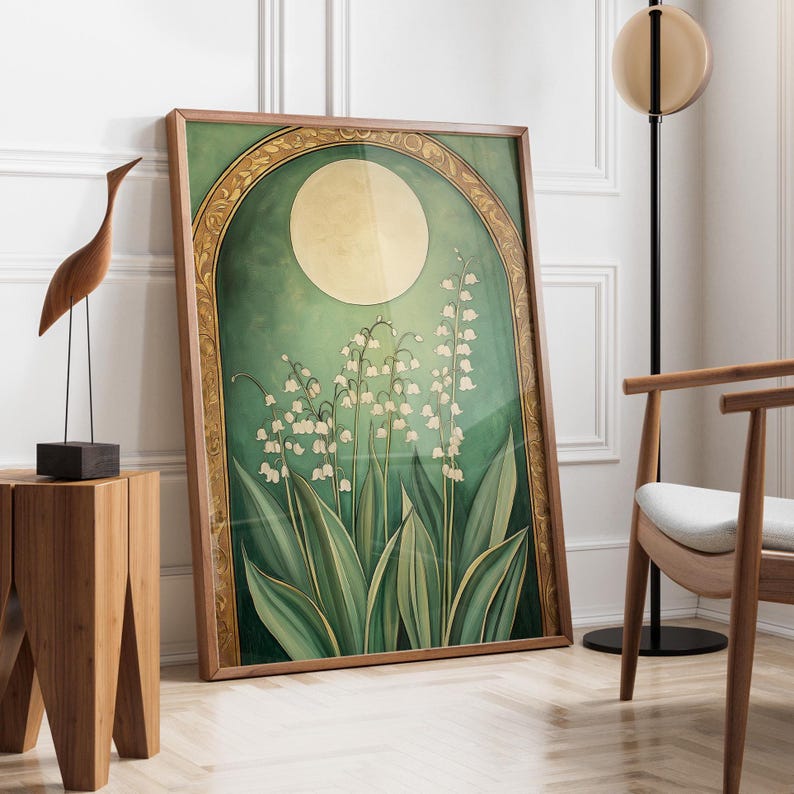 May include: A framed art print featuring a botanical illustration of lily of the valley flowers. The artwork has a green and gold color scheme with a large moon in the background. The frame is made of wood.