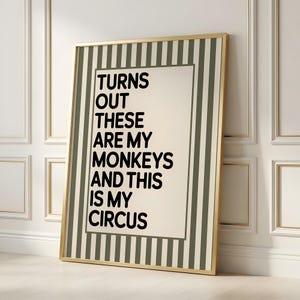 May include: A framed print with the text "TURNS OUT THESE ARE MY MONKEYS AND THIS IS MY CIRCUS" in black. The frame has a gold border and a striped background in shades of green and cream.