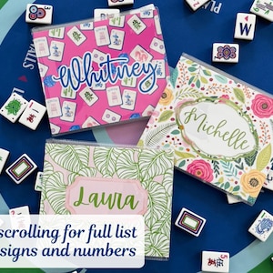 May include: Three personalized Mahjong tile cases with names: "Whitney" on pink, "Michelle" on floral, and "Laura" on green leaf pattern. Mahjong tiles surround the cases on a blue surface. Text at the bottom says "Keep scrolling for full list of designs and numbers."