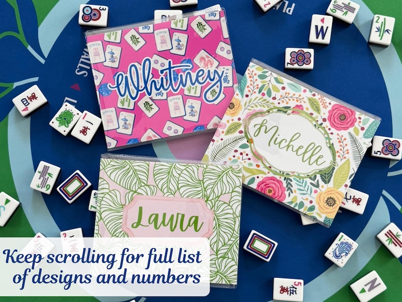 May include: Three personalized Mahjong tile cases with names: "Whitney" on pink, "Michelle" on floral, and "Laura" on green leaf pattern. Mahjong tiles surround the cases on a blue surface. Text at the bottom says "Keep scrolling for full list of designs and numbers."