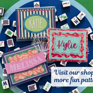 May include: Three personalized gift boxes with names "Katie", "Kylie", and "Melissa" in different fonts and colors. The boxes are surrounded by Mahjong tiles on a blue and green patterned surface. Text on the image says "Visit our shop for more fun patterns!"