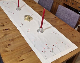 Caminho de mesa de linho bordado à mão com flores vermelhas.