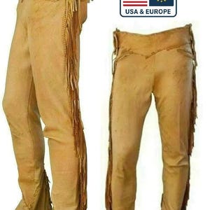 Puede incluir: Pantalones de cuero color beige con flecos en los laterales. Los pantalones tienen una cintura alta con botones. La imagen también incluye un gráfico con el texto "DELIVERED DUTY PAID" y "USA & EUROPE".