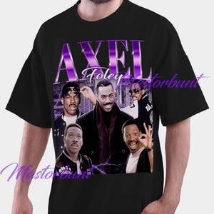 May include: Black t-shirt featuring a graphic of Axel Foley with the text "AXEL Foley" in purple. The graphic includes multiple images of the character. A classic movie-themed tee.