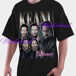 May include: Black t-shirt featuring a collage of Keanu Reeves images with the name "Keanu Reeves" in gold and pink text. The shirt has a crew neck and short sleeves.