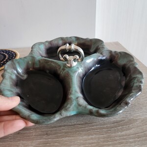 Puede incluir: Un plato de servir de cerámica de tres secciones con un asa plateada. El plato es verde y negro con un patrón de mármol.