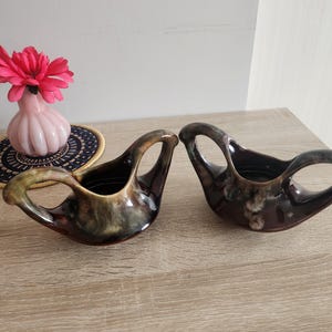 Peut inclure: Deux plats de service en céramique brun et vert avec un design abstrait unique. Les plats ont deux poignées de chaque côté et sont parfaits pour servir des sauces ou des trempettes.