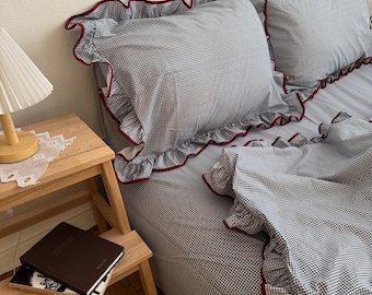 Juego de ropa de cama de algodón con volantes y estampado de cuadros azul marino: funda nórdica, sábana bajera y fundas de almohada.