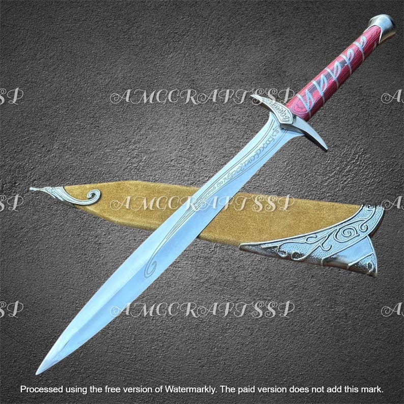 May include: A silver fantasy sword with a red and silver handle, resting in a tan sheath. The blade has etched designs. The handle is wrapped in red and silver. The sheath has silver accents. The image has the text "AMCCRAFT SSP".