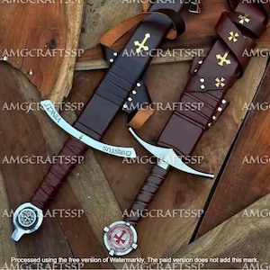 May include: Two medieval swords with brown leather-wrapped handles and sheaths. The blades are silver with inscriptions. One sword has a cross emblem on the hilt, and the other has a circular emblem with a red cross.