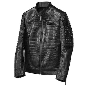 Puede incluir: Chaqueta de cuero negra con un patrón texturizado similar al de un cocodrilo. La chaqueta tiene cuello alto, cierre de cremallera y detalles de botones. Las mangas tienen un diseño acolchado. Una prenda de abrigo elegante.