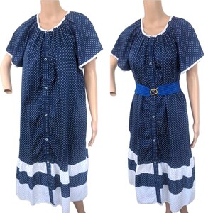 May include: A navy blue and white polka dot dress with a white ruffle trim and a button-up front. The dress has short sleeves and a gathered neckline.